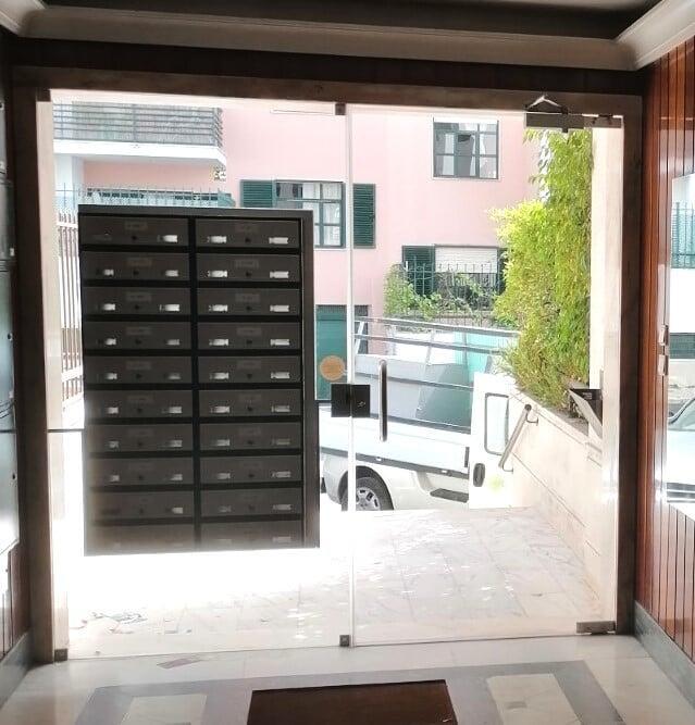 porta de condominio em vidro com caixas de correio